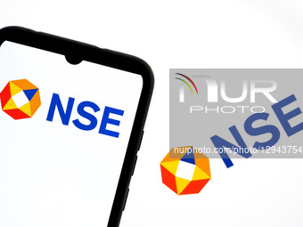 The NSE - National Stock Exchange of India logo appears on a smartphone screen and as the background on a laptop computer screen in this pho... by Nikolas Kokovlis/NurPhoto