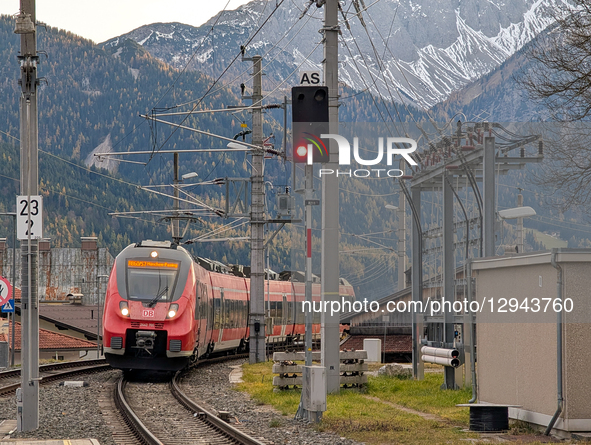 A red DB Regio train arrives at the Ehrwald Zugspitzbahn station platform, where travelers wait in Ehrwald, Tyrol, Austria, on November 1, 2... by Michael Nguyen/NurPhoto