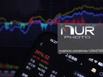 The closing points of the Shanghai Composite Index of China display on a smartphone with the stock curve chart in the background in Haian, J... by Costfoto/NurPhoto