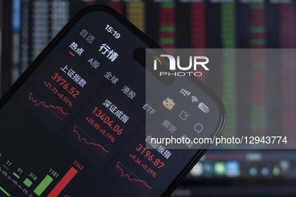 The closing points of the Shanghai Composite Index of China display on a smartphone with the stock curve chart in the background in Haian, J... by Costfoto/NurPhoto