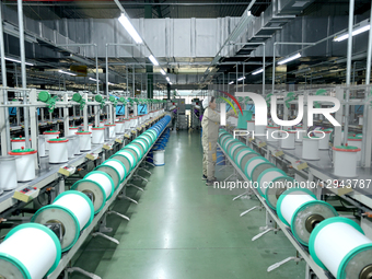 A worker works on intelligent textile equipment in Suqian City, Jiangsu Province, China, on November 3, 2025.  by Costfoto/NurPhoto