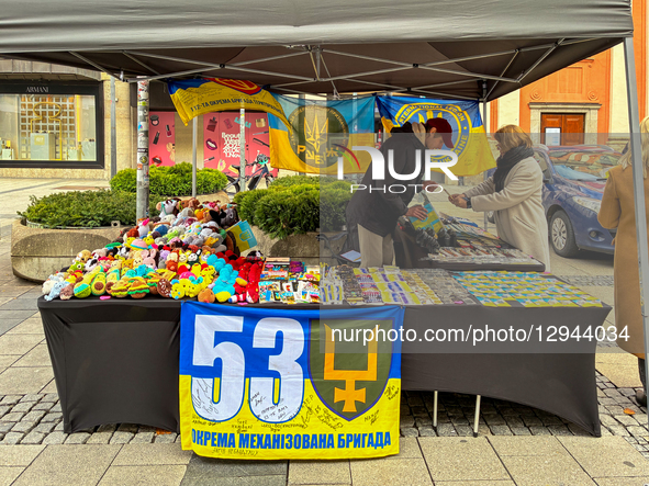 A charity stall sells souvenirs and Ukrainian flags to raise funds for the military, specifically referencing the 53rd Mechanized Brigade an... by Michael Nguyen/NurPhoto