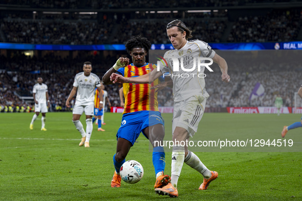 Alvaro Carreras of Real Madrid receives a foul from Thierry Rendall of Valencia CF during the LaLiga EA Sports football match between Real M... by Alberto Gardin/NurPhoto