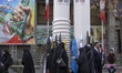 Veiled Iranian women gather under scale models of Iran-made ballistic missiles, two centri...