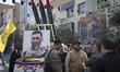 A group of unidentified Iranian men stands together next to scale models of Iran-made miss...