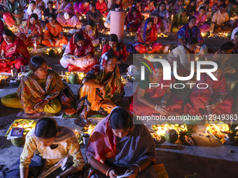 Hindu devotees sit together with oil lamps to pray to Lokenath Brahmachari, a Hindu saint and philosopher, as they observe the Rakher Upobas... by Kazi Salahuddin Razu/NurPhoto