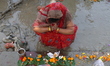 Hindu people offer prayers after floating small decorated boats made with banana stems as...