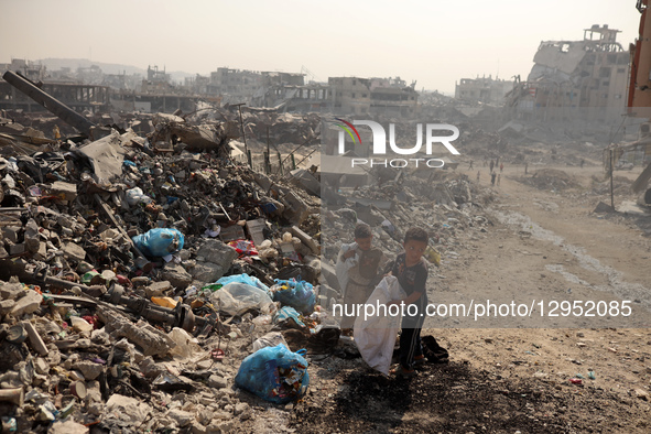 Palestinians walk amid the rubble of destroyed buildings in Gaza City, Palestine, on November 5, 2025, during a ceasefire in the two-year-lo... by Majdi Fathi/NurPhoto