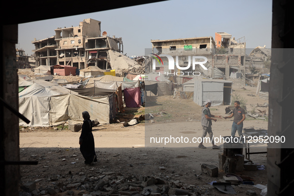 Palestinians walk amid the rubble of destroyed buildings in Gaza City, Palestine, on November 5, 2025, during a ceasefire in the two-year-lo... by Majdi Fathi/NurPhoto