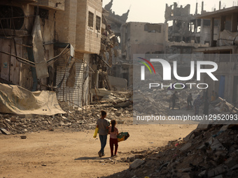 Palestinians walk amid the rubble of destroyed buildings in Gaza City, Palestine, on November 5, 2025, during a ceasefire in the two-year-lo... by Majdi Fathi/NurPhoto