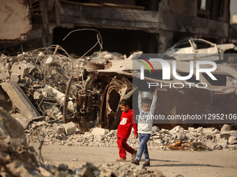 A young Palestinian boy carries a pot of rice he receives at a shelter where families live in Gaza City, on November 5, 2025.  by Majdi Fathi/NurPhoto