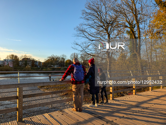 People In Autumn On The Flauchersteg Footbridge Over The Isar River In Munich