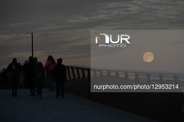 A Beaver supermoon rises behind the pedestrian bridge over the Vistula River in Warsaw, Poland, on November 5, 2025  by Aleksander Kalka/NurPhoto