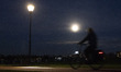 The largest full moon of 2025, a supermoon know as Beaver Moon rises while a bicycles pass...