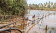 A man repairs a broken spring water pipe to supply water to a village near a nickel mining...
