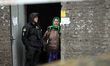 A National Police of Ukraine officer speaks with a resident of a four-storey residential b...
