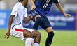 Futa Takeno of Japan and Darryl Hmaloko of New Caledonia are in action during the FIFA U-1...