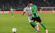Valentin Gomez of Real Betis competes for the ball with Ainsley Maitland-Niles of Olympiqu...