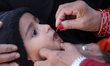 A Nepali health worker administers the Oral Polio Vaccine (OPV) to a Nepali child at an in...