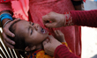A Nepali health worker administers the Oral Polio Vaccine (OPV) to a Nepali child at an in...