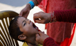 A Nepali health worker administers the Oral Polio Vaccine (OPV) to a Nepali child at an in...