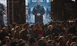 Iranian people sit under a display depicting a symbolic image of Brigadier General Amir Al...