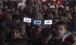 Young Iranian women hold up their cell phones with Persian words that read, (R to L) My Li...