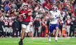 Wisconsin Badgers quarterback Carter Smith (5) attempts a pass while Washington Huskies li...