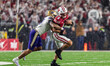 Wisconsin Badgers quarterback Carter Smith (5) is tackled by Washington Huskies linebacker...