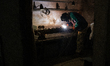 A worker welds spare parts for military armored vehicles in a repair shop of one of the mi...
