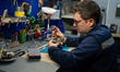 A master restores a telescopic sight in a repair shop of one of the military logistical su...