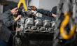 Workers restore damaged military equipment in a repair shop of one of the military logisti...