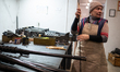 A worker restores machine guns in a repair shop of one of the military logistical support...