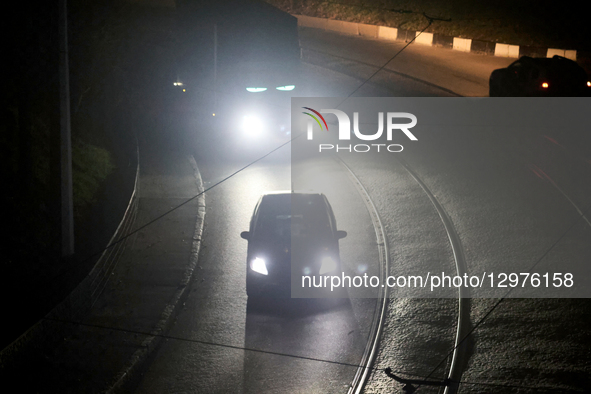 Cars illuminate a road with headlights in complete darkness in Kharkiv, Ukraine, on November 8, 2025. Dozens of streets and neighborhoods ar... by Viacheslav Madiievskyi/Ukrinform/NurPhoto