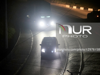 Cars illuminate a road with headlights in complete darkness in Kharkiv, Ukraine, on November 8, 2025. Dozens of streets and neighborhoods ar... by Viacheslav Madiievskyi/Ukrinform/NurPhoto