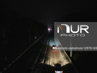 Cars illuminate a road with headlights in complete darkness in Kharkiv, Ukraine, on November 8, 2025. Dozens of streets and neighborhoods ar... by Viacheslav Madiievskyi/Ukrinform/NurPhoto