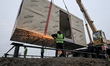 Workers install houses at the site of a modular town for internally displaced persons in Z...