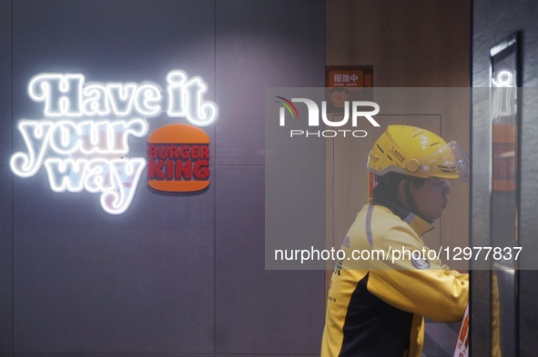 A courier waits to pick up food at a Burger King store in Hangzhou, Zhejiang Province, China, on November 11, 2025.  by Costfoto/NurPhoto