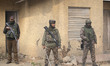 Indian security personnel guard at a polling station during the Budgam Assembly constituen...