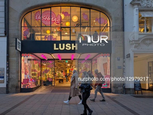 The storefront of the LUSH cosmetics store features a large, illuminated logo, pink lights, and arched windows decorated for the ''Lushmas''... by Michael Nguyen/NurPhoto
