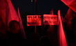 People hold up Poland's national flags and signs reading ''Tusk German Puppet'' and ''Inde...