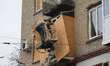 Workers seal a damaged balcony with a particle board in the Kholodnohirskyi district after...