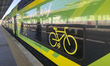 A close-up of the bicycle symbol is inside a Trenitalia regional train carriage with dedic...