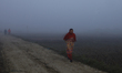 A Nepali woman in warm clothes walks on a foggy winter morning in Lalitpur, Nepal, on Nove...