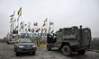Military vehicles park at the road sign marking the limits of the Zaporizhzhia (former Ori...
