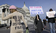 Demonstrators hold signs during the Epstein Files Transparency Act news conference in Wash...