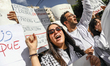 A young doctor shouts slogans while raising her fist during a rally organized by the Tunis...