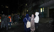 Residents gather outside a mid-rise damaged by a Russian drone strike in Kharkiv, Ukraine,...