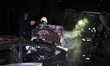 Firefighters put out a smoldering vehicle during cleanup operations after a Russian drone...