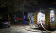 Rescuers involved in eliminating the consequences of a Russian drone attack talk by a fire...